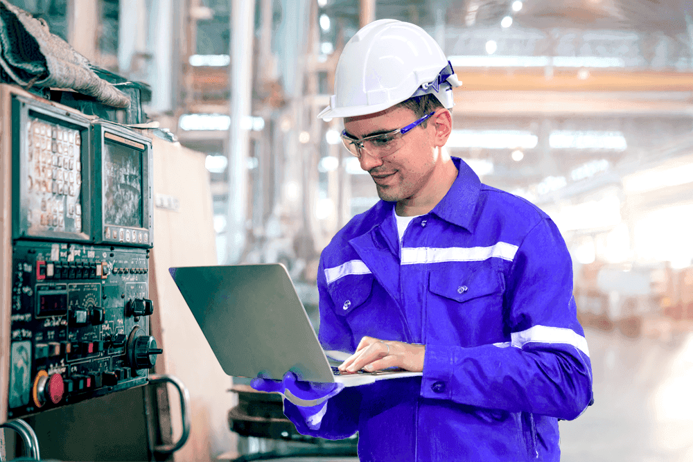 Plant manager with a laptop in a factory setting