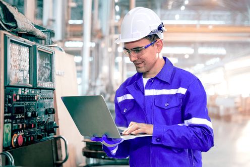 Plant manager with a laptop in a factory setting