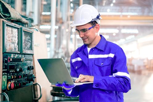 Plant manager with a laptop in a factory setting