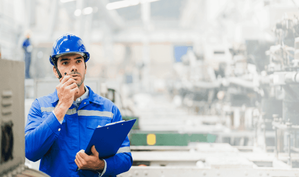 Plant manager with a walkie-talkie in a factory setting